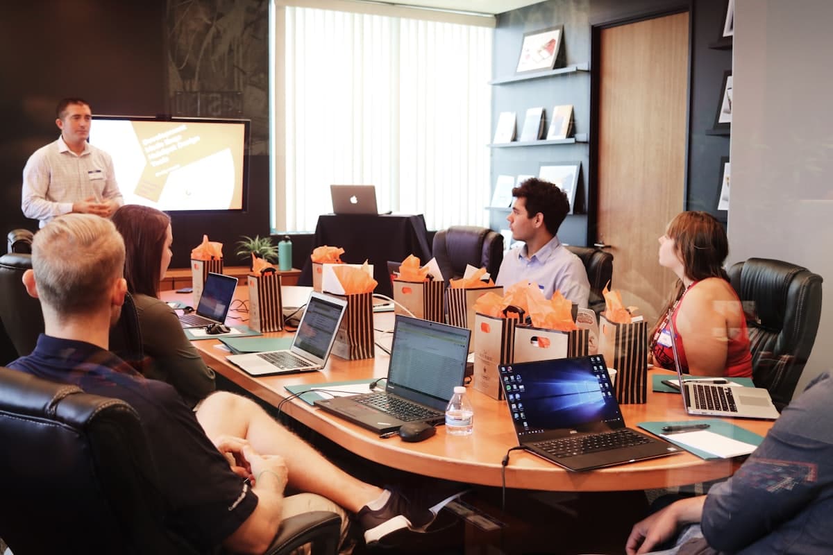 Business team meeting around a conference table with laptops